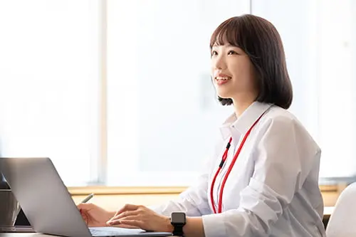 ノートパソコンを操作する女性インストラクター